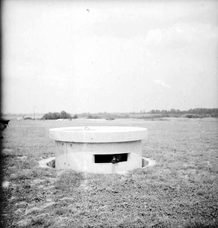 The turret of a Pickett-Hamilton Retractable Fort, fully raised and manned by a bren-gun team of the Coldstream Guards, taken on a fighter airfield in Southern England. ROYAL AIR FORCE FIGHTER COMMAND, 1939-1945 © IWM (CH 17890) IWM Non Commercial Licence